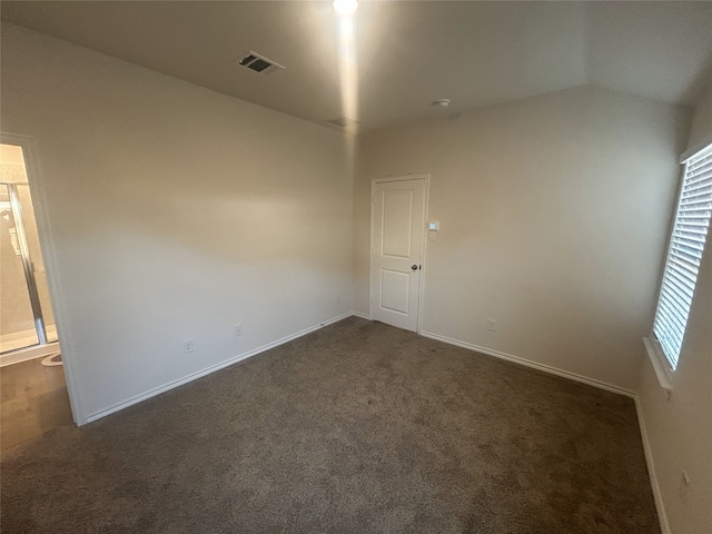 carpeted empty room with lofted ceiling