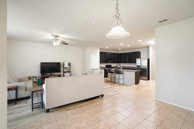 tiled living room featuring sink and ceiling fan