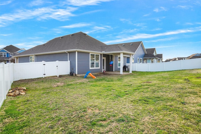 back of property with a yard and a patio