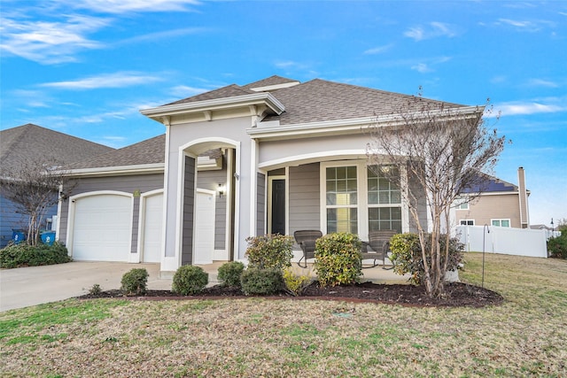 view of front of house featuring a porch, a garage, and a front yard