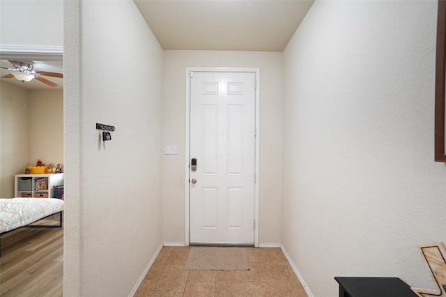 entryway featuring light tile patterned floors and ceiling fan