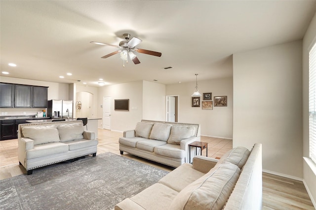 living room with ceiling fan and sink