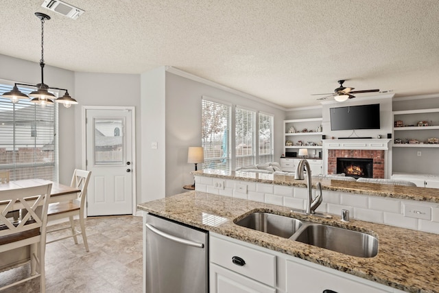 kitchen with sink, white cabinetry, dishwasher, pendant lighting, and light stone countertops