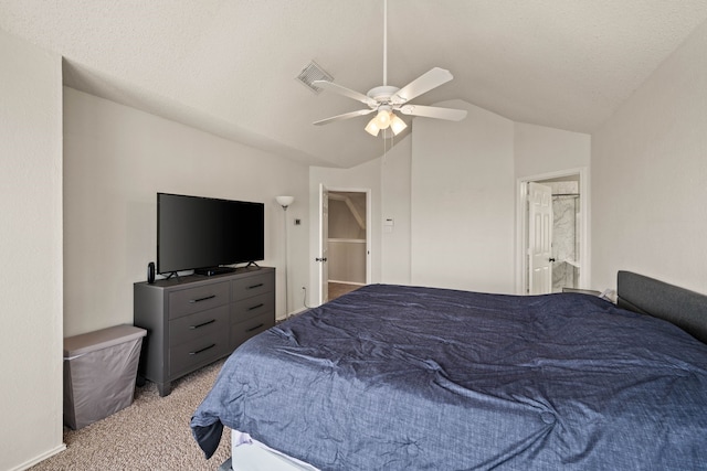 bedroom with lofted ceiling, connected bathroom, light colored carpet, a textured ceiling, and ceiling fan