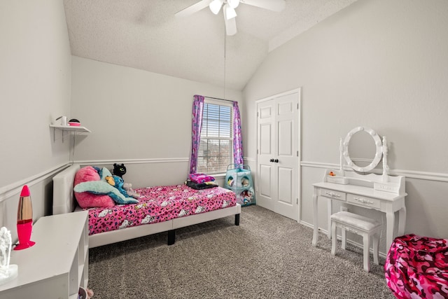 bedroom featuring vaulted ceiling, carpet flooring, ceiling fan, and a textured ceiling