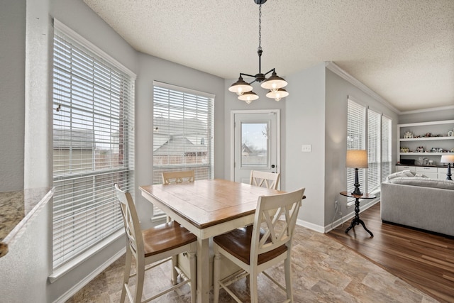 dining space featuring an inviting chandelier, wood-type flooring, and a textured ceiling