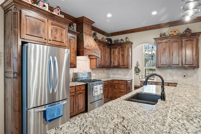 kitchen featuring stainless steel appliances, light stone countertops, sink, and decorative backsplash