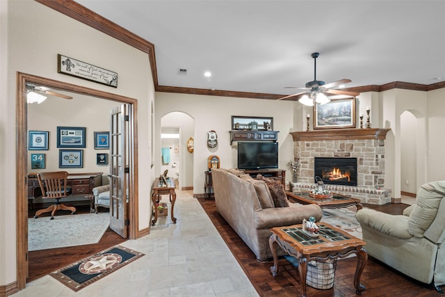 living room featuring a fireplace, ornamental molding, and ceiling fan