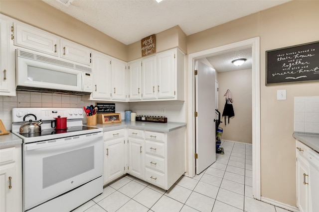 kitchen featuring light tile patterned flooring, backsplash, white cabinets, white appliances, and a textured ceiling