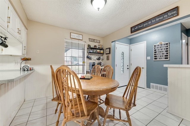 tiled dining area featuring a textured ceiling