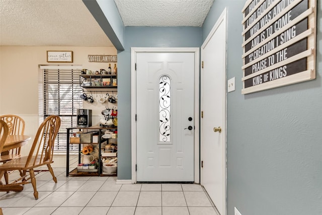 tiled foyer entrance featuring a textured ceiling