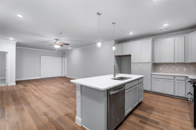 kitchen with visible vents, backsplash, a sink, light wood-style flooring, and stainless steel dishwasher