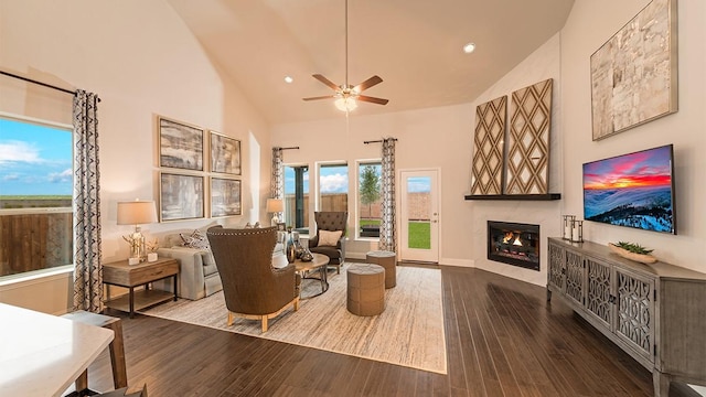 living room with ceiling fan, wood-type flooring, and high vaulted ceiling