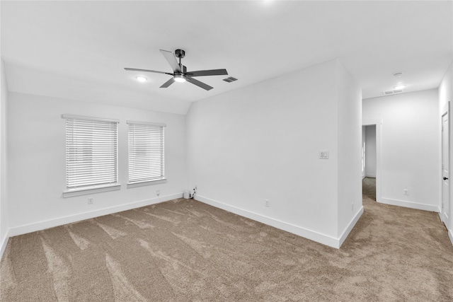 spare room featuring ceiling fan, vaulted ceiling, and light colored carpet