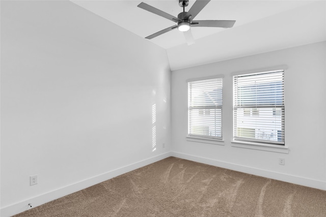 carpeted empty room featuring vaulted ceiling and ceiling fan