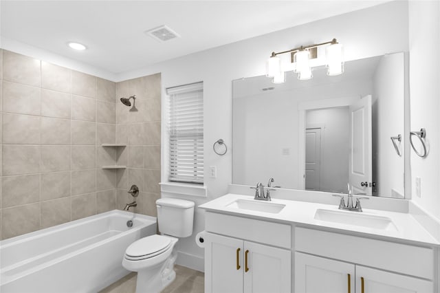 full bathroom featuring tiled shower / bath combo, vanity, and toilet