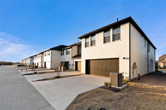 view of front of property with central air condition unit and a garage