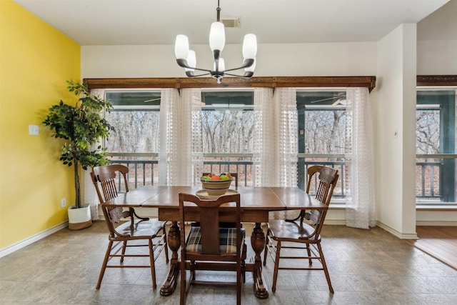 dining space with baseboards, a chandelier, and a wealth of natural light