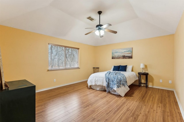 bedroom with visible vents, wood finished floors, baseboards, a ceiling fan, and vaulted ceiling