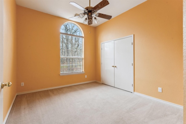 unfurnished bedroom with a ceiling fan, baseboards, carpet, and a closet