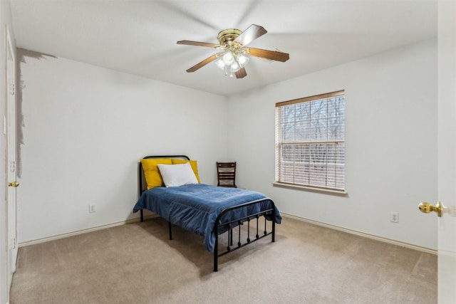 carpeted bedroom featuring baseboards and ceiling fan