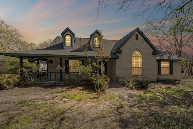 view of front of home featuring covered porch and brick siding