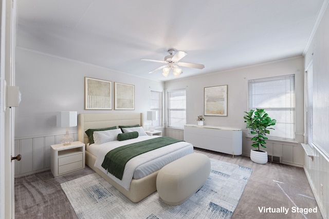 carpeted bedroom with crown molding and ceiling fan