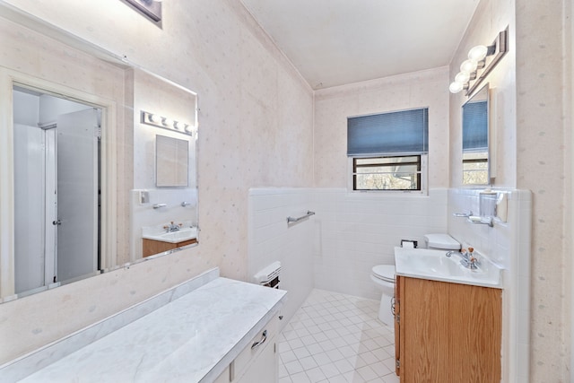 bathroom with vanity, tile patterned floors, tile walls, and toilet