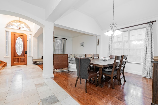 dining space with lofted ceiling, crown molding, a chandelier, and light hardwood / wood-style floors