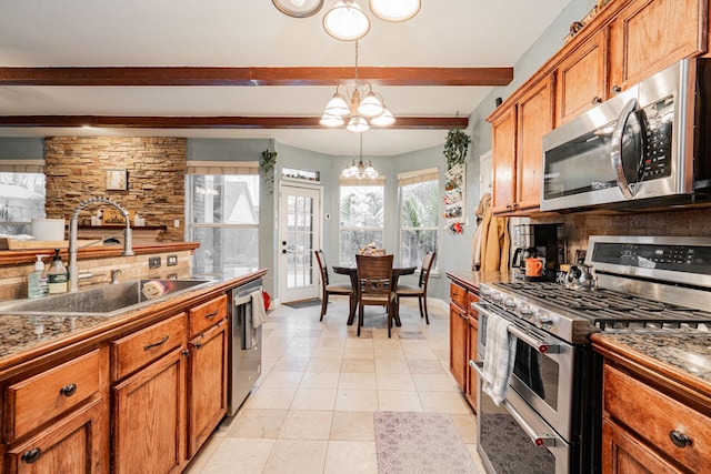 kitchen featuring appliances with stainless steel finishes, beam ceiling, a notable chandelier, pendant lighting, and sink