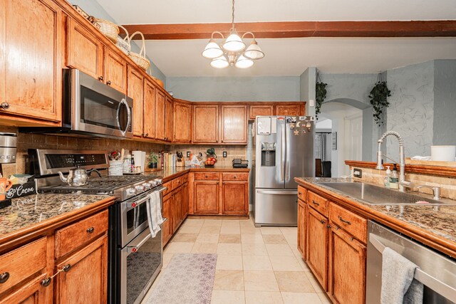 kitchen with appliances with stainless steel finishes, sink, backsplash, and beam ceiling