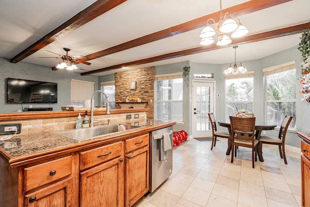 kitchen with sink, ceiling fan with notable chandelier, stainless steel dishwasher, hanging light fixtures, and beam ceiling