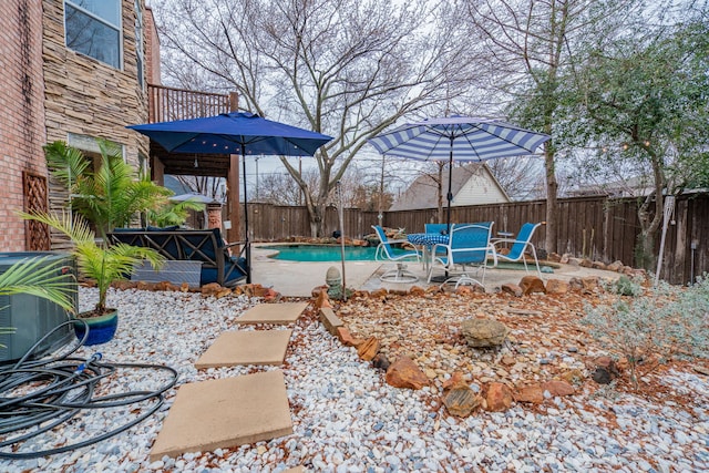 view of yard featuring central air condition unit, a fenced in pool, and a patio area