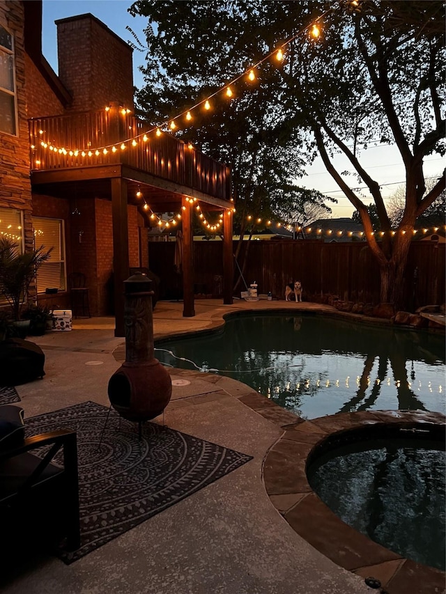 pool at dusk with a patio