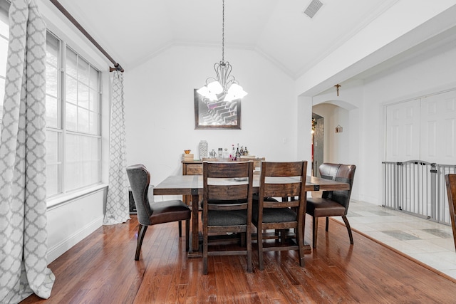 dining room with ornamental molding, vaulted ceiling, dark hardwood / wood-style floors, and a notable chandelier