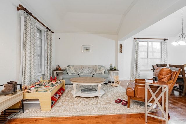 living room with ornamental molding, a chandelier, and wood-type flooring