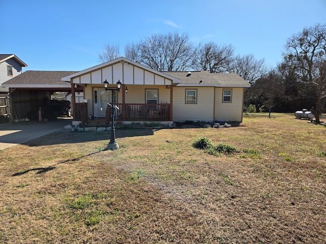 ranch-style house featuring a front yard, a carport, and covered porch