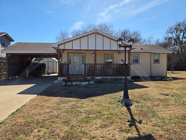 view of front facade featuring a storage shed, a front yard, a carport, and covered porch