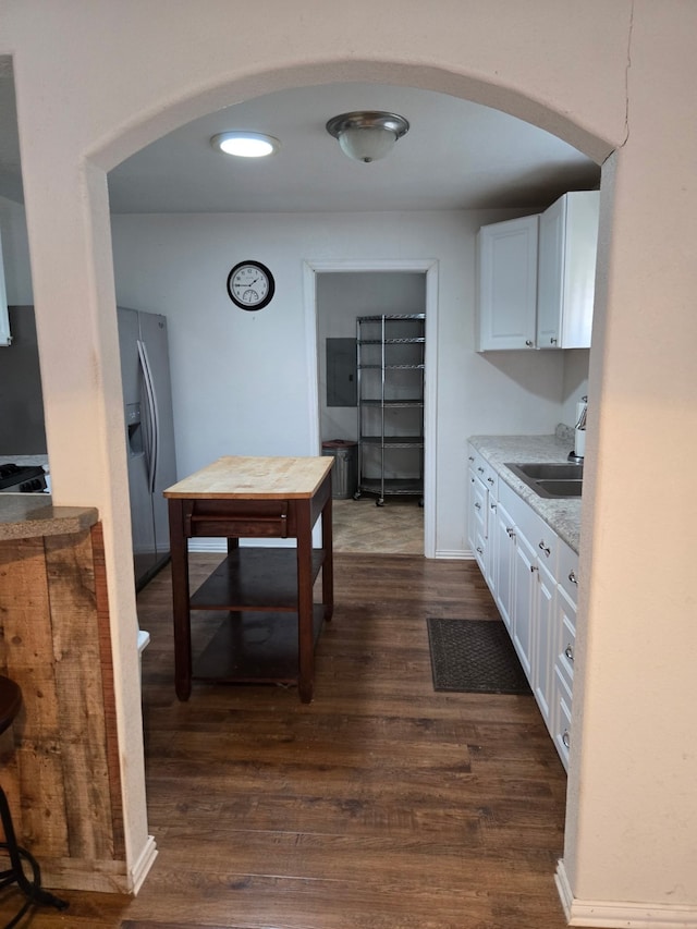 kitchen with white cabinetry, dark hardwood / wood-style floors, sink, and stainless steel fridge with ice dispenser