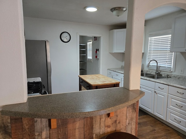 kitchen with wooden counters, sink, white cabinets, and dark hardwood / wood-style floors