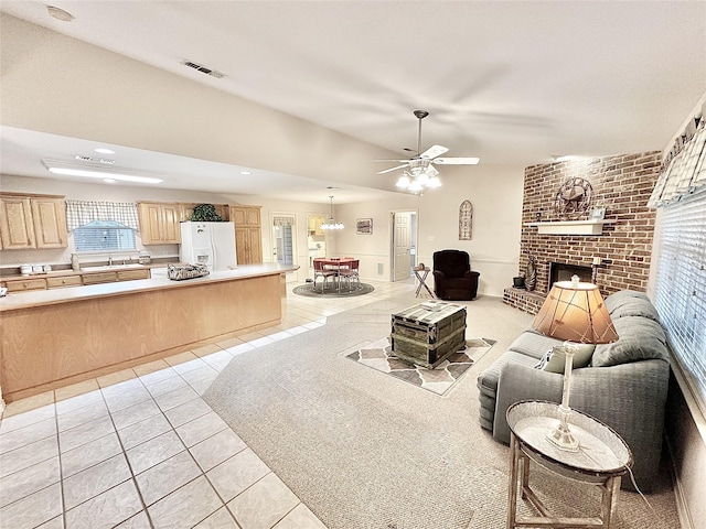 living room featuring light tile patterned flooring, ceiling fan, and a fireplace