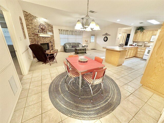 tiled dining room featuring a notable chandelier and a brick fireplace