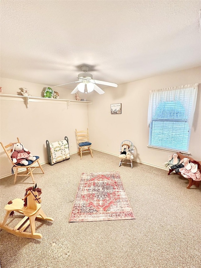 rec room with ceiling fan, carpet floors, and a textured ceiling