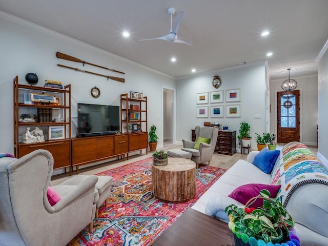 living room with ornamental molding, light wood-type flooring, and ceiling fan