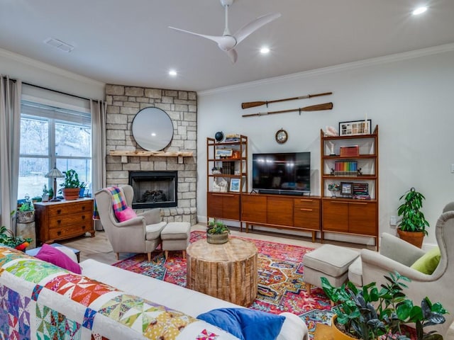 living room featuring ceiling fan, ornamental molding, and a fireplace