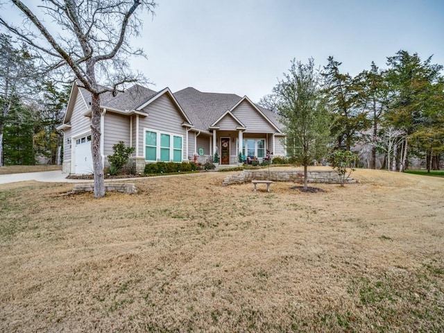 view of front of home featuring a garage, a porch, and a front lawn