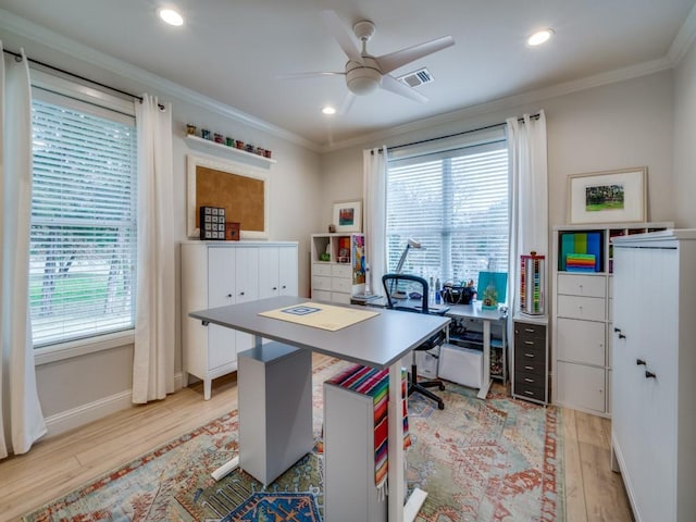 home office with crown molding, a wealth of natural light, and light wood-type flooring