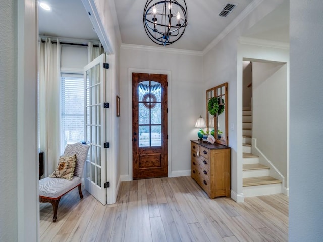 foyer featuring ornamental molding, light hardwood / wood-style floors, and a notable chandelier