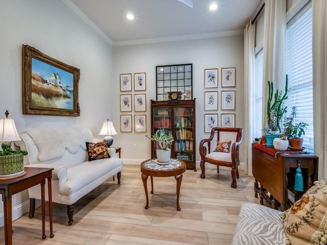 sitting room with ornamental molding and light wood-type flooring