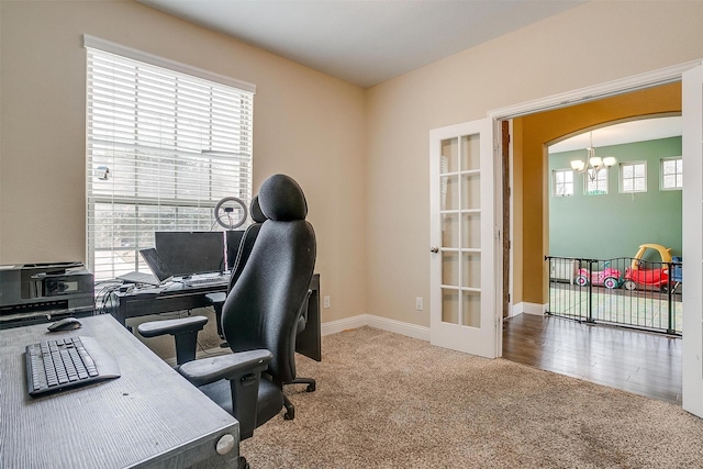 office area with french doors, a chandelier, and carpet